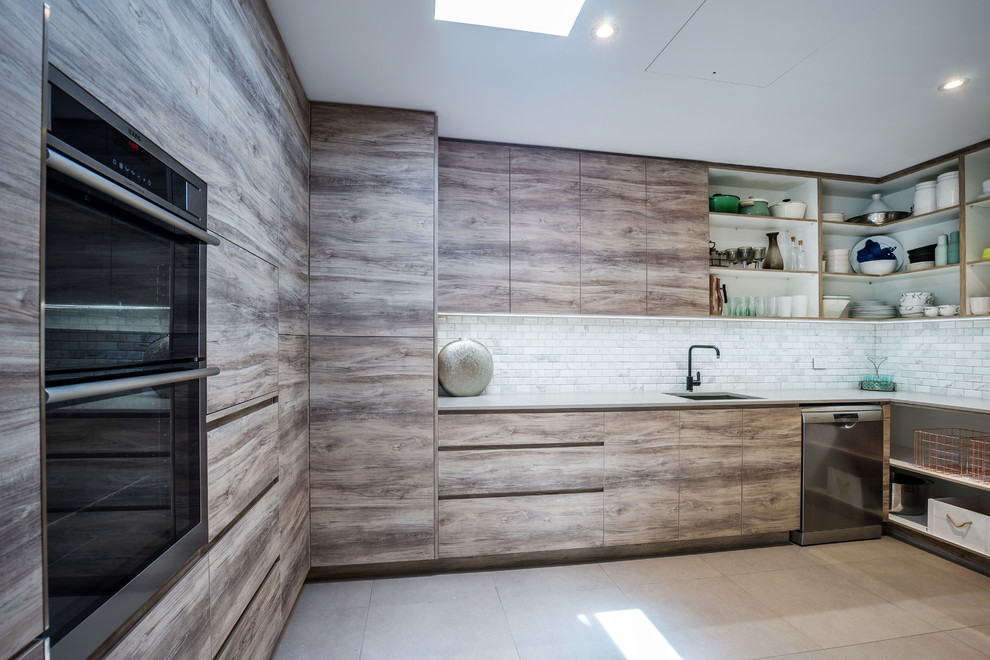 Inspiration for an expansive contemporary kitchen pantry in Sunshine Coast with an undermount sink, flat-panel cabinets, medium wood cabinets, concrete benchtops, grey splashback, stone tile splashback, black appliances, porcelain floors and no island.