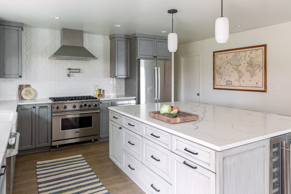 Inspiration for a mid-sized midcentury eat-in kitchen in San Diego with a farmhouse sink, shaker cabinets, grey cabinets, quartz benchtops, white splashback, ceramic splashback, stainless steel appliances, vinyl floors, with island, brown floor and white benchtop.