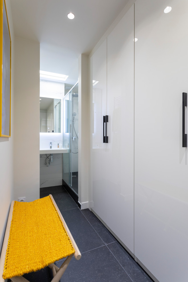 Idéer för ett litet modernt omklädningsrum för könsneutrala, med släta luckor, vita skåp, skiffergolv och grått golv