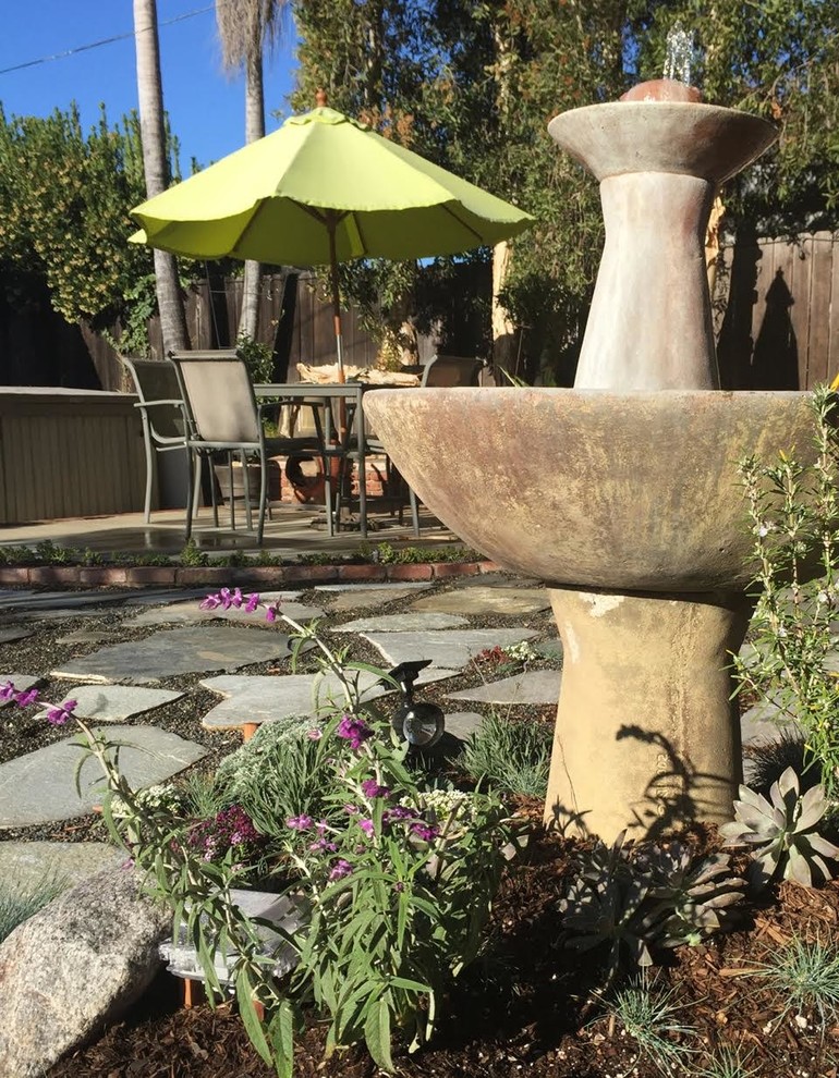 Mid-sized transitional backyard full sun xeriscape in Orange County with natural stone pavers and a water feature for spring.