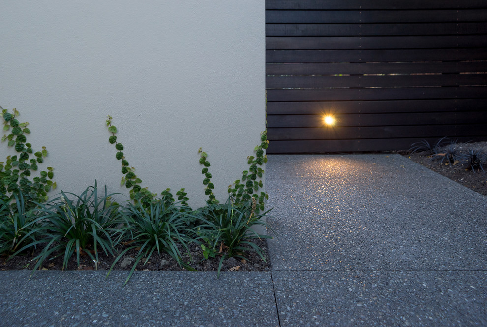 This is an example of a small contemporary front yard patio in Christchurch with stamped concrete and no cover.