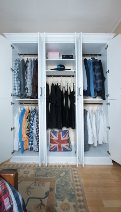 Foto de armario unisex tradicional de tamaño medio con armarios con paneles con relieve, puertas de armario blancas y suelo de madera clara