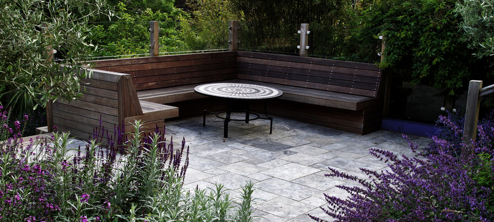 Mid-sized contemporary backyard full sun xeriscape in Sussex with natural stone pavers for summer.