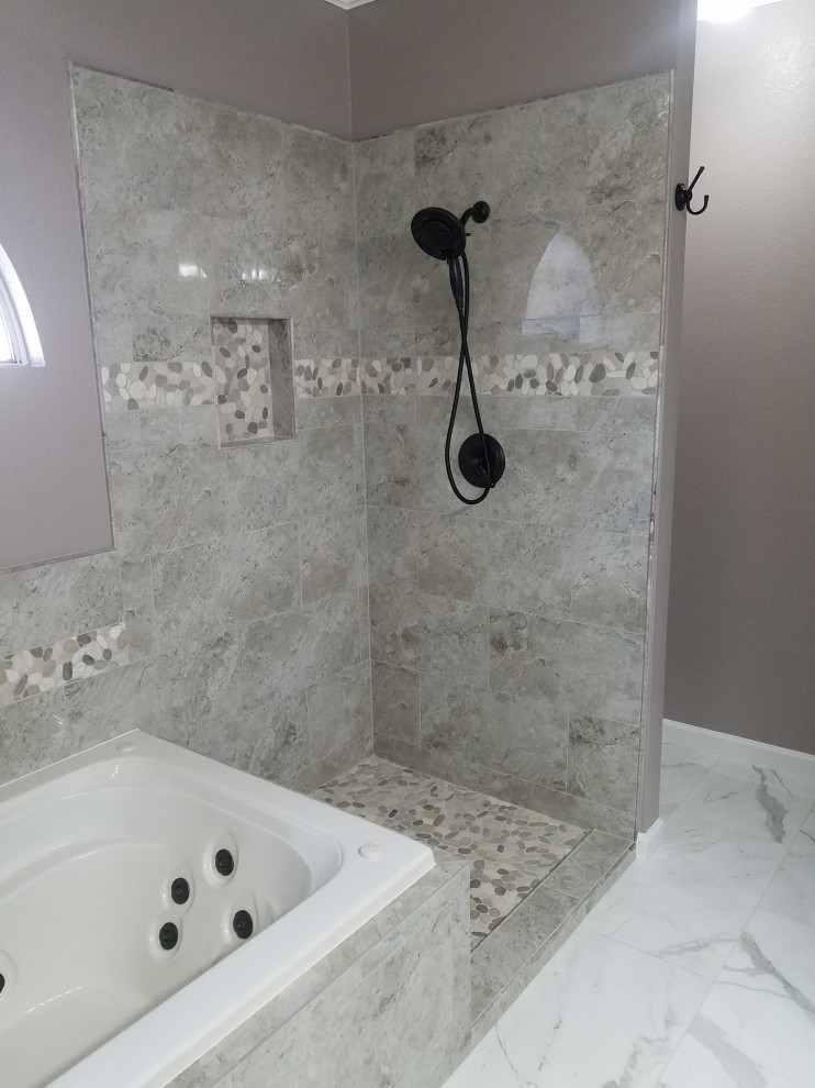 This is an example of a mid-sized traditional master bathroom in Dallas with raised-panel cabinets, dark wood cabinets, a drop-in tub, a corner shower, a two-piece toilet, gray tile, porcelain tile, purple walls, porcelain floors, an undermount sink, granite benchtops, white floor, a hinged shower door, beige benchtops, a double vanity and a built-in vanity.