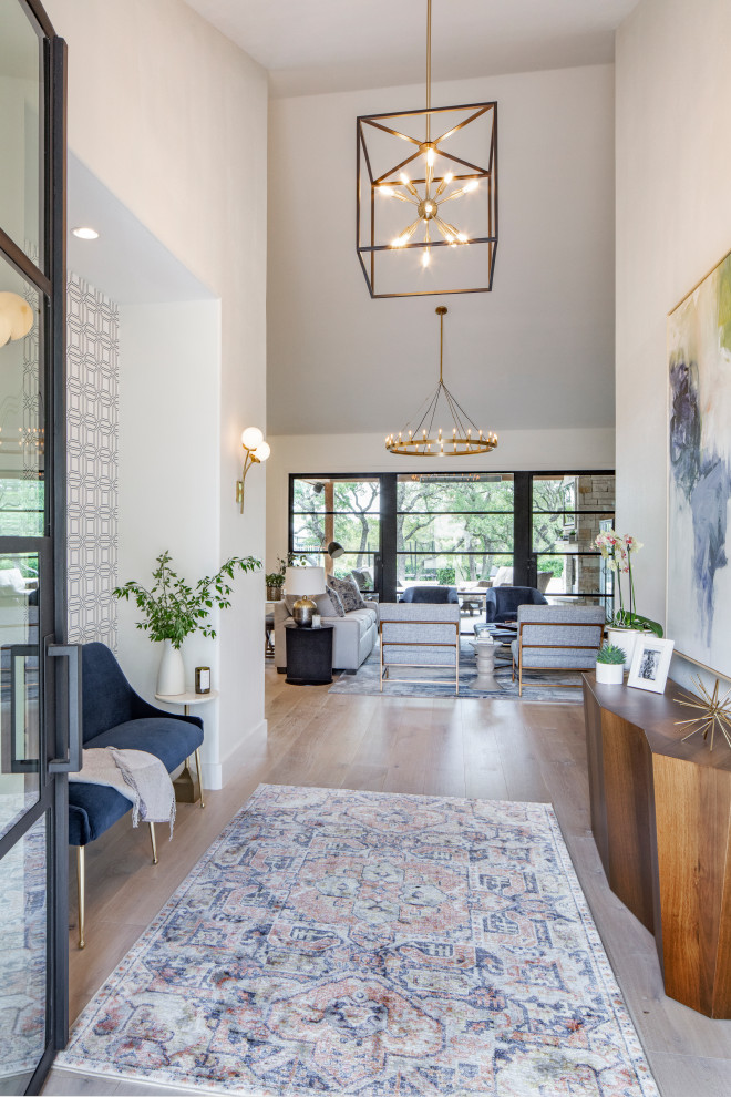 Mid-sized transitional light wood floor and beige floor foyer photo in Austin with white walls and a glass front door