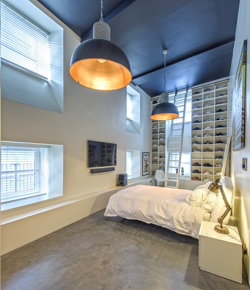 Inspiration for a mid-sized industrial bedroom in Other with white walls, concrete floors and grey floor.