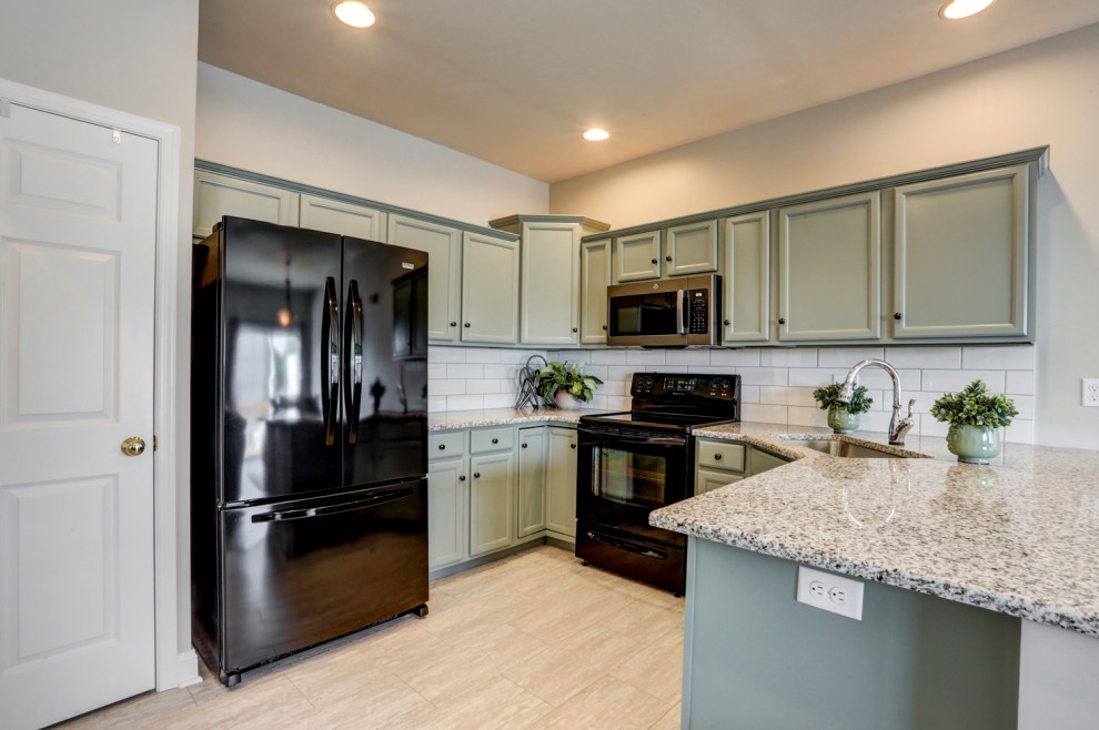Mid-sized transitional u-shaped vinyl floor and gray floor eat-in kitchen photo with an undermount sink, recessed-panel cabinets, green cabinets, granite countertops, white backsplash, subway tile backsplash, black appliances, a peninsula and gray countertops