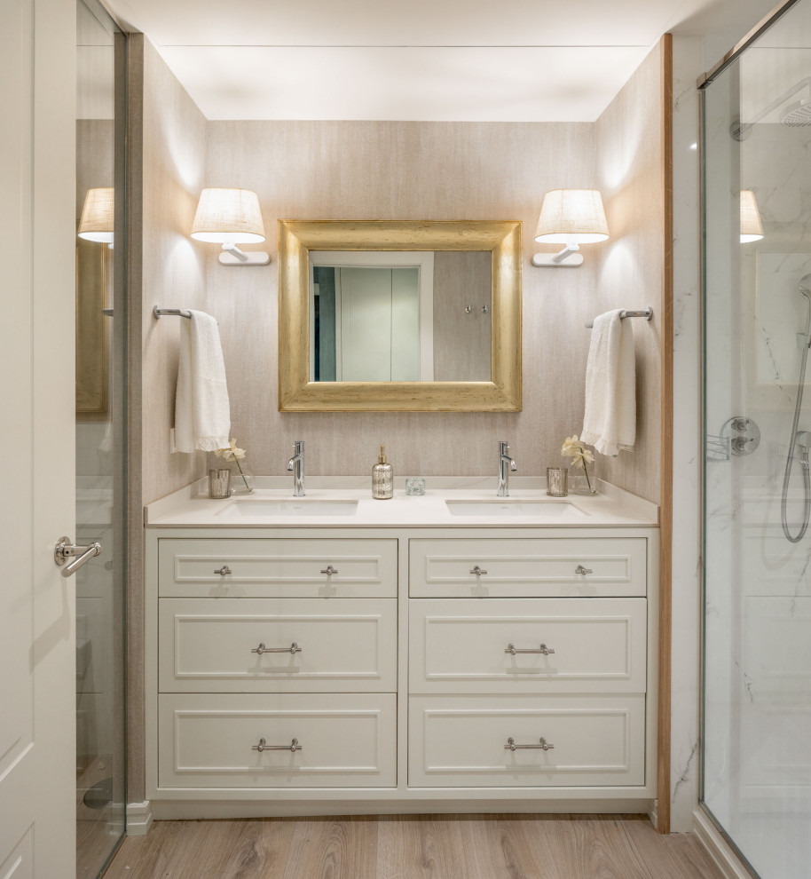 Foto på ett stort vintage beige en-suite badrum, med luckor med profilerade fronter, vita skåp, en kantlös dusch, en vägghängd toalettstol, beige väggar, laminatgolv, ett undermonterad handfat, bänkskiva i kvarts och dusch med gångjärnsdörr