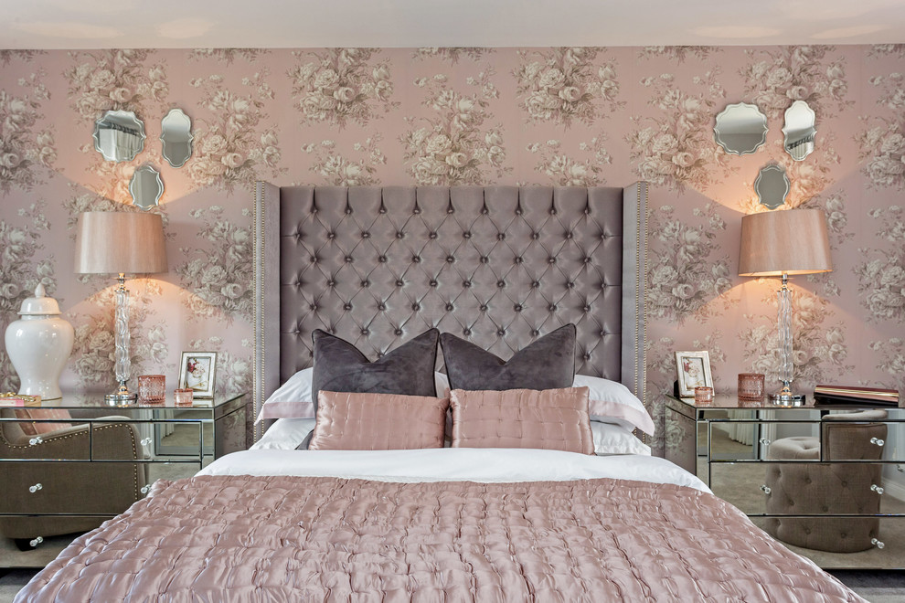 Photo of a transitional bedroom in Buckinghamshire with pink walls, carpet and grey floor.