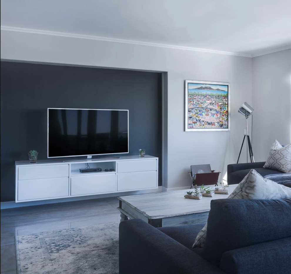 На фото: открытая гостиная комната среднего размера в стиле неоклассика (современная классика) с серыми стенами, полом из ламината, отдельно стоящим телевизором и серым полом без камина с