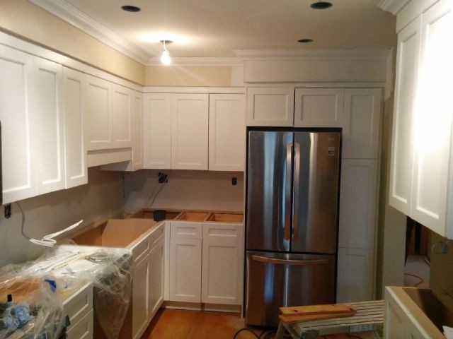 Inspiration for a mid-sized transitional u-shaped light wood floor open concept kitchen remodel in Toronto with a drop-in sink, shaker cabinets, white cabinets, stainless steel appliances and a peninsula