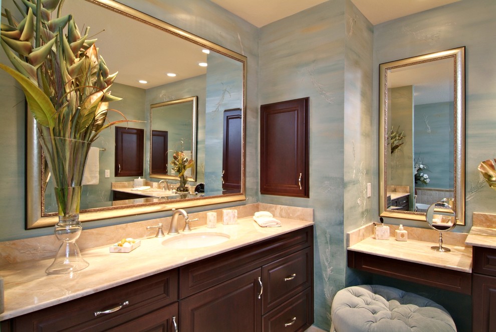 Inspiration for a mid-sized tropical master bathroom in Tampa with an undermount sink, raised-panel cabinets, dark wood cabinets, marble benchtops, a drop-in tub, a corner shower, a two-piece toilet, beige tile, stone tile, blue walls and travertine floors.