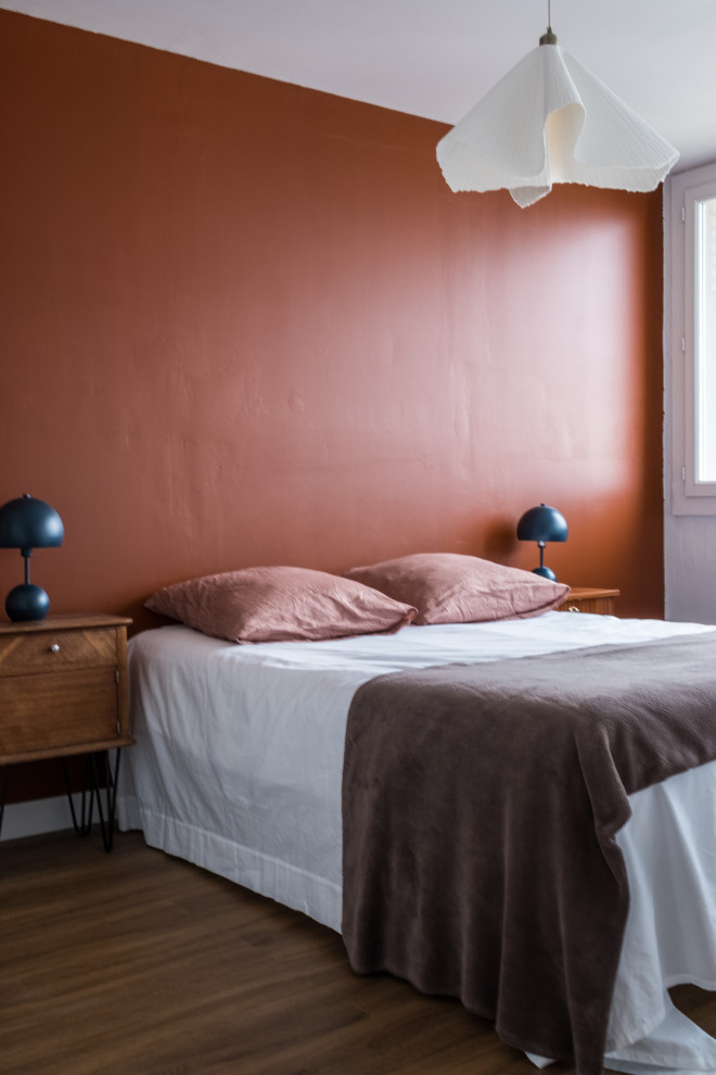 Imagen de dormitorio principal actual de tamaño medio con paredes rojas y suelo de madera oscura