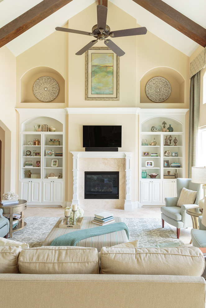 Design ideas for a large traditional open concept living room in Houston with yellow walls, travertine floors, a standard fireplace, a tile fireplace surround and a wall-mounted tv.