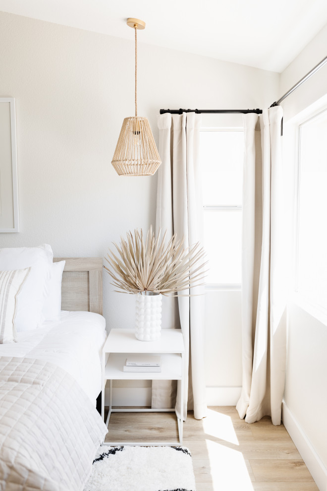 Small beach style master vinyl floor, brown floor and vaulted ceiling bedroom photo in Phoenix with white walls and no fireplace
