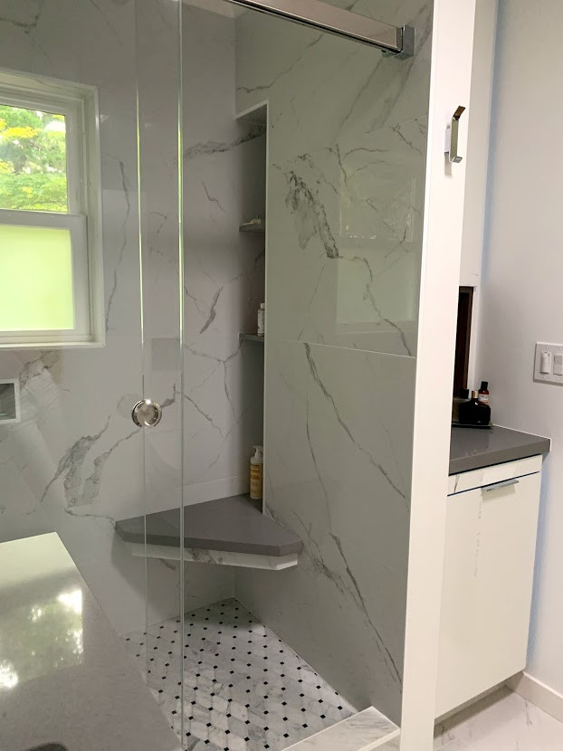 This is an example of a mid-sized contemporary 3/4 bathroom in San Francisco with flat-panel cabinets, medium wood cabinets, an alcove shower, gray tile, marble, white walls, marble floors, an undermount sink, engineered quartz benchtops, grey floor, a sliding shower screen and grey benchtops.