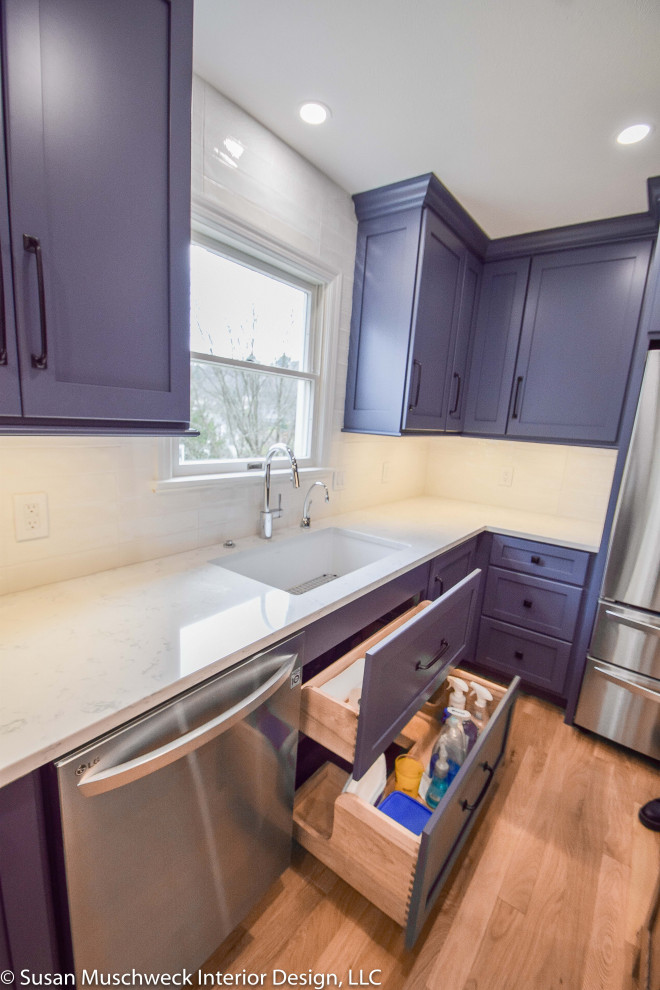 Enclosed kitchen - mid-sized transitional l-shaped light wood floor enclosed kitchen idea with an undermount sink, shaker cabinets, blue cabinets, quartz countertops, white backsplash, ceramic backsplash, stainless steel appliances, an island and white countertops