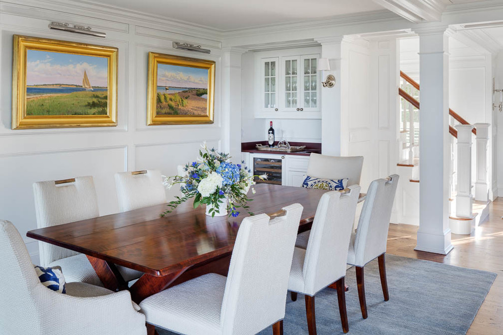 This is an example of a mid-sized beach style open plan dining in Boston with white walls and medium hardwood floors.