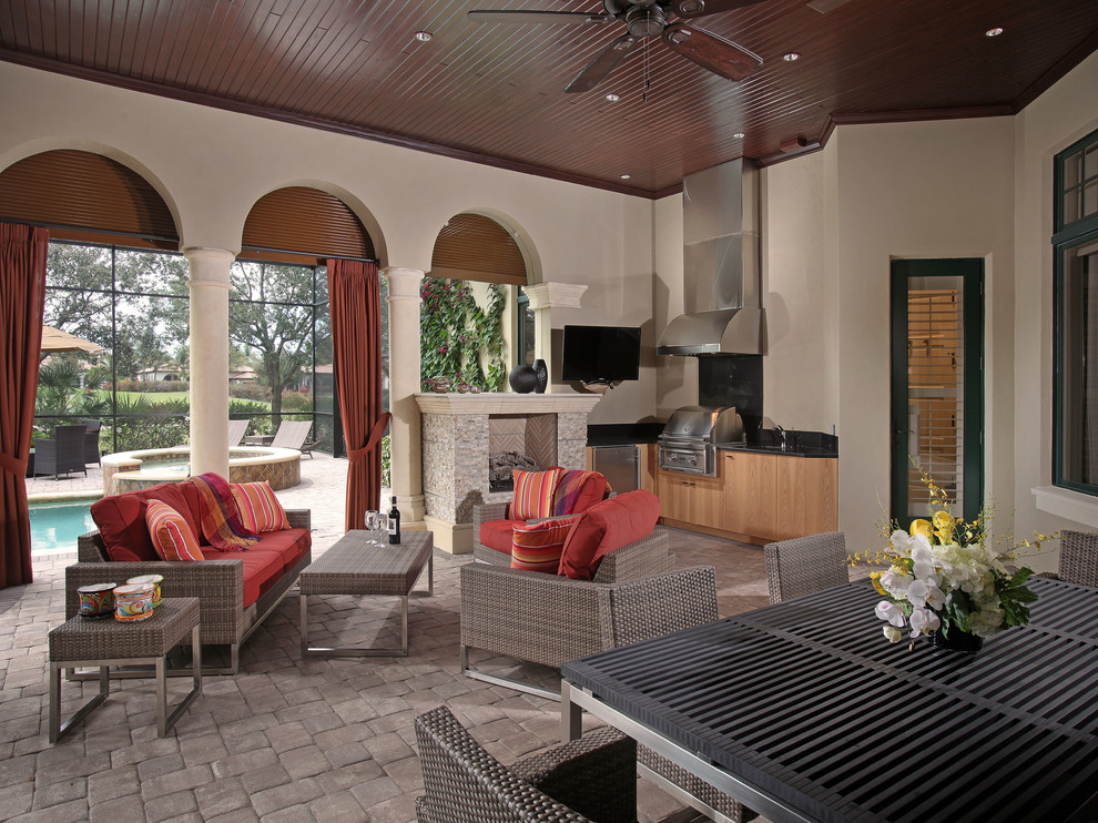 Large transitional backyard brick patio kitchen photo in Miami with a roof extension