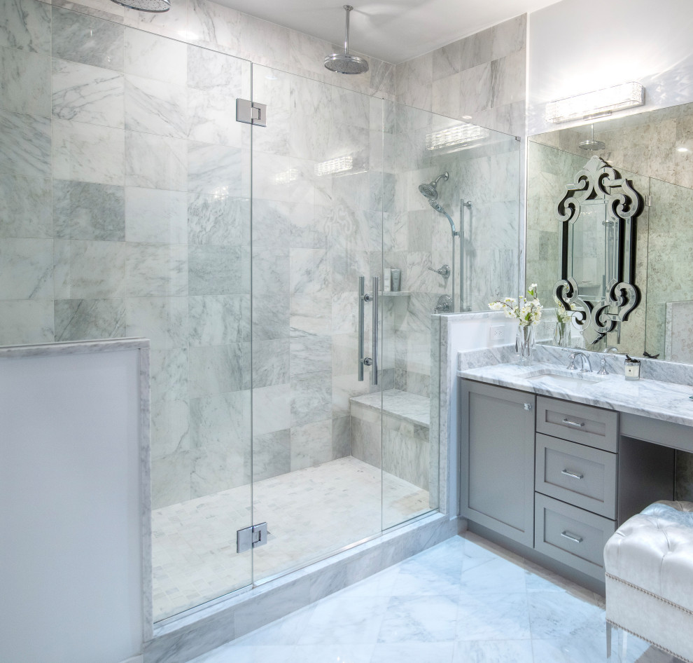 Photo of an expansive contemporary master bathroom in New York with shaker cabinets, grey cabinets, a double shower, a two-piece toilet, gray tile, marble, white walls, marble floors, an undermount sink, marble benchtops, grey floor, a hinged shower door, white benchtops, an enclosed toilet, a double vanity and a built-in vanity.