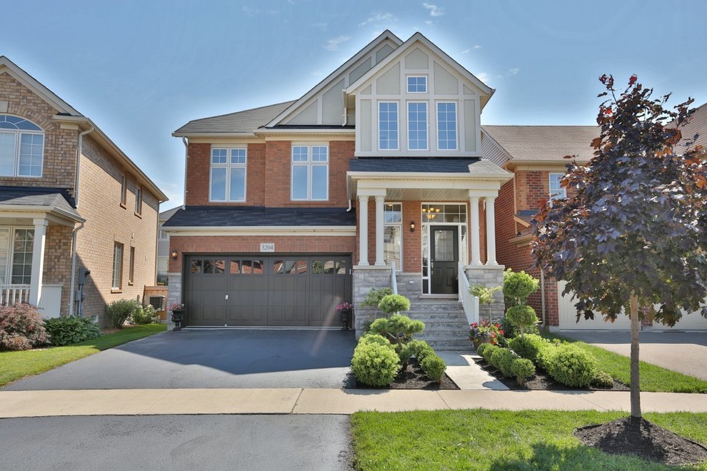 This is an example of a large arts and crafts two-storey brick red exterior in Toronto.