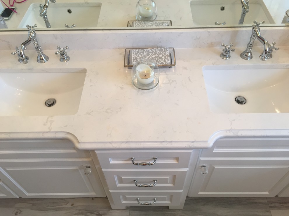 Large traditional kids bathroom in Chicago with raised-panel cabinets, white cabinets, a shower/bathtub combo, a two-piece toilet, blue walls, vinyl floors, an undermount sink and engineered quartz benchtops.