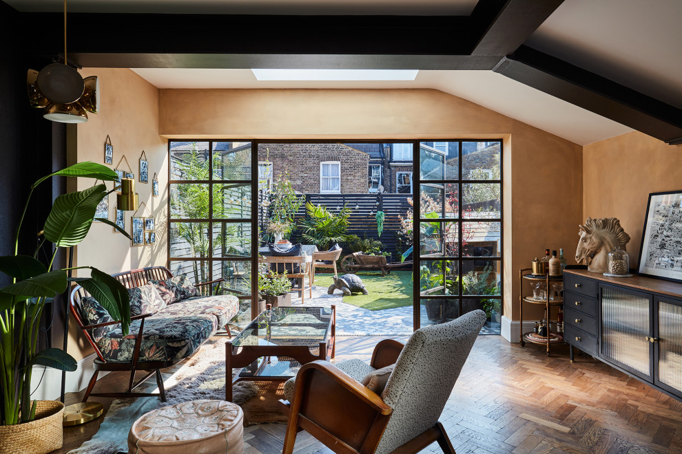 Mittelgroßes, Fernseherloses Eklektisches Wohnzimmer ohne Kamin mit Hausbar, beiger Wandfarbe, braunem Holzboden, braunem Boden und freigelegten Dachbalken in London