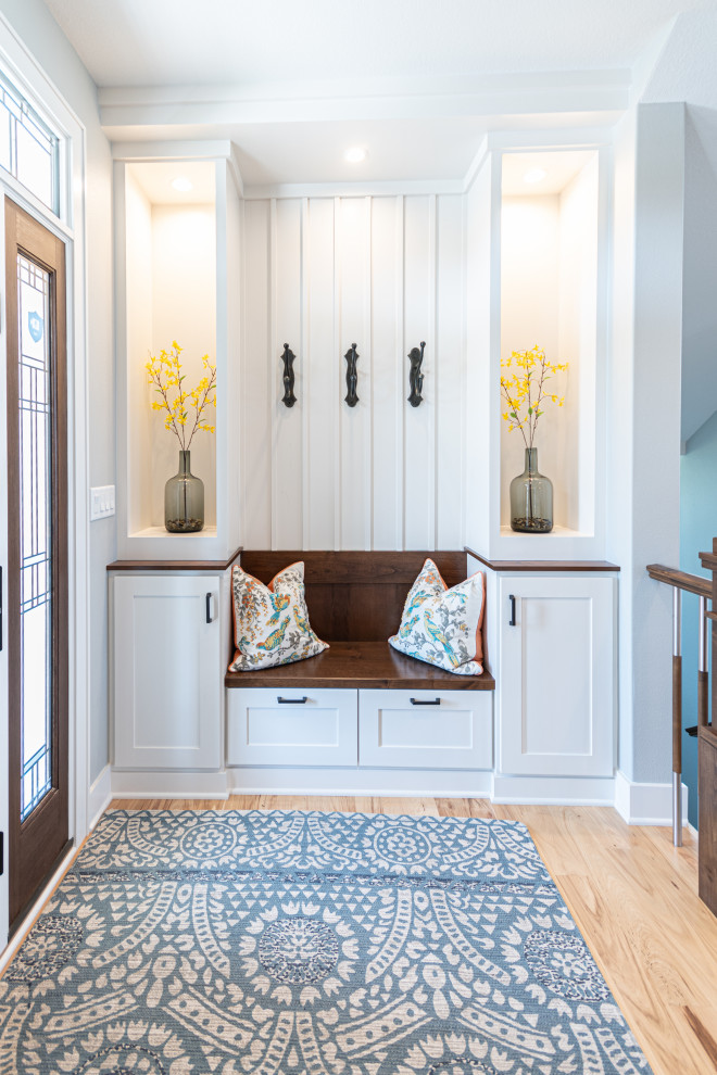 Design ideas for a transitional mudroom in Other with white walls, light hardwood floors, a single front door, a medium wood front door and beige floor.