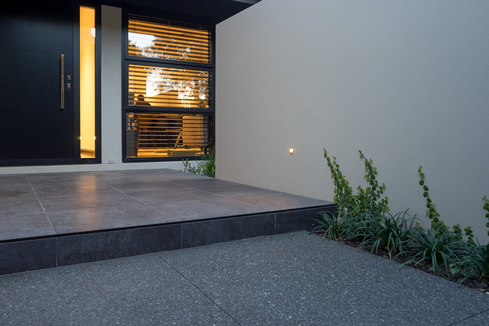 Inspiration for a contemporary entryway in Christchurch with beige walls and a black front door.