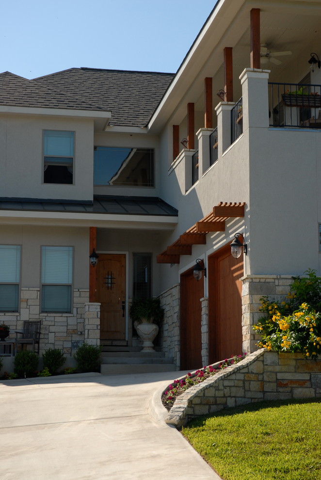 This is an example of a mid-sized transitional two-storey stucco beige exterior in Austin with a hip roof.