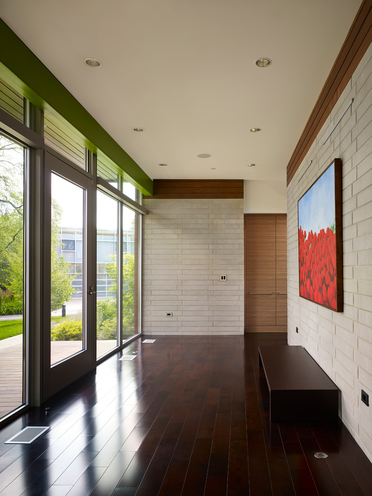 Photo of a large contemporary entry hall in Chicago with white walls, vinyl floors, a single front door and brown floor.