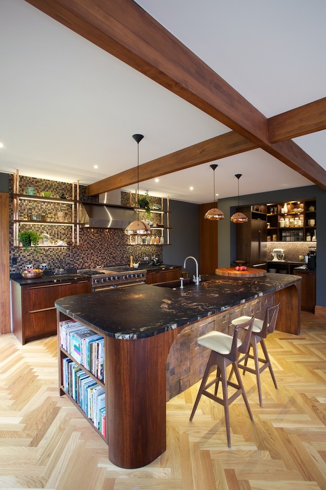 This is an example of a large contemporary galley eat-in kitchen in Auckland with flat-panel cabinets, dark wood cabinets, brown splashback, mosaic tile splashback, light hardwood floors, with island, a farmhouse sink, granite benchtops and stainless steel appliances.