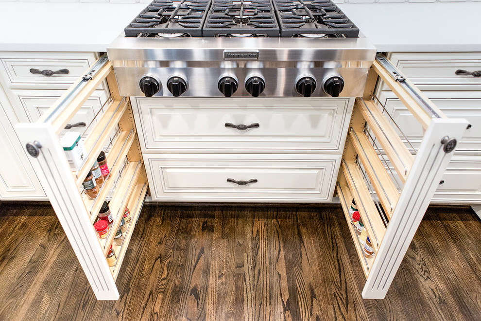 Open concept kitchen - large l-shaped medium tone wood floor open concept kitchen idea in Birmingham with a farmhouse sink, raised-panel cabinets, white cabinets, granite countertops, white backsplash, ceramic backsplash, stainless steel appliances and an island