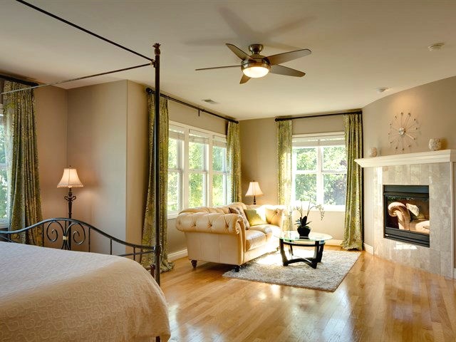 Inspiration for an expansive transitional master bedroom in San Francisco with grey walls, light hardwood floors, a standard fireplace and a stone fireplace surround.