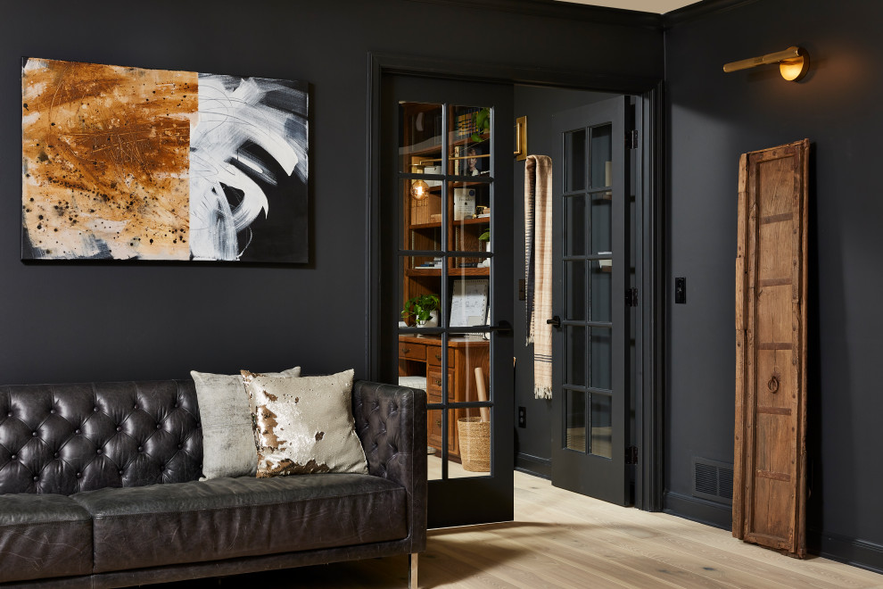 Foto på ett mellanstort funkis hemmastudio, med svarta väggar, ljust trägolv, ett fristående skrivbord och beiget golv