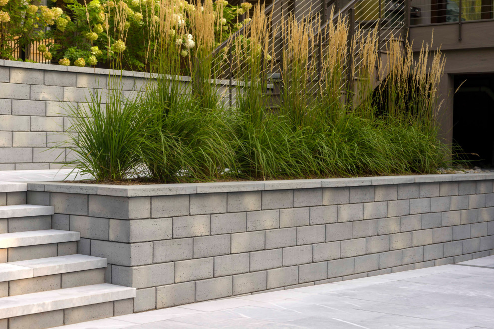 This is an example of a modern front yard garden in New York with concrete pavers.