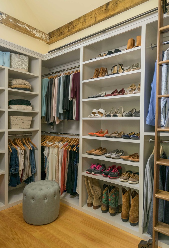 Photo of a mid-sized country walk-in wardrobe in Boston with open cabinets, white cabinets and medium hardwood floors.