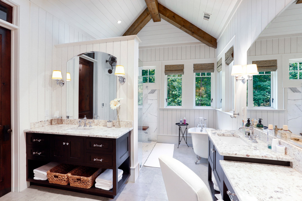 This is an example of a large beach style master bathroom in Atlanta with shaker cabinets, dark wood cabinets, a claw-foot tub, white walls, porcelain floors, an undermount sink, granite benchtops and grey floor.