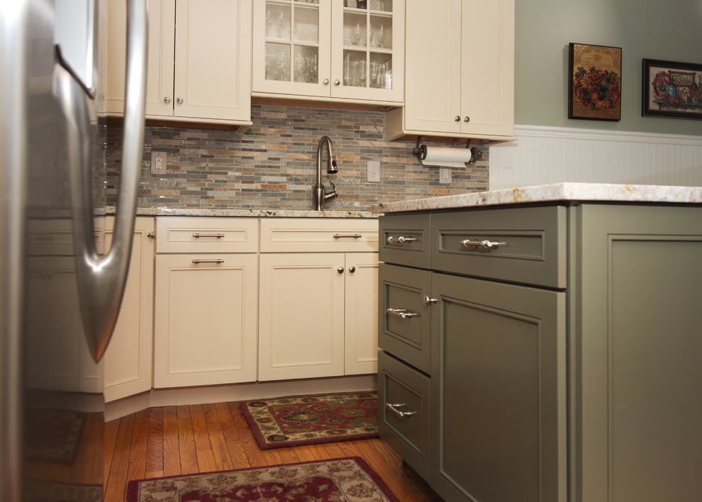 Mid-sized traditional l-shaped eat-in kitchen in Philadelphia with an undermount sink, shaker cabinets, beige cabinets, granite benchtops, grey splashback, glass sheet splashback, stainless steel appliances, medium hardwood floors, with island and beige floor.