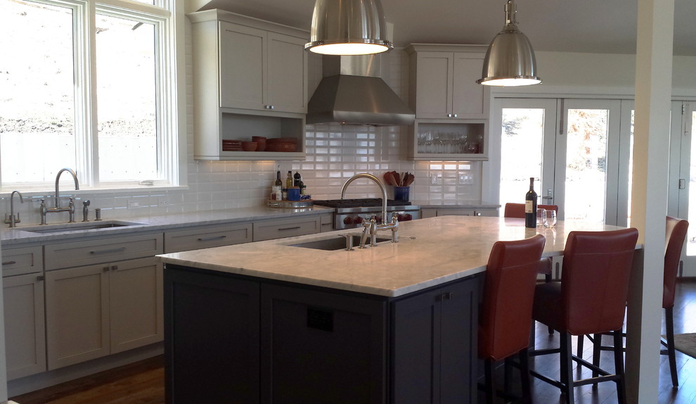 Example of a large medium tone wood floor kitchen design in Denver with a single-bowl sink, shaker cabinets, white cabinets, quartz countertops, white backsplash, ceramic backsplash, stainless steel appliances and an island