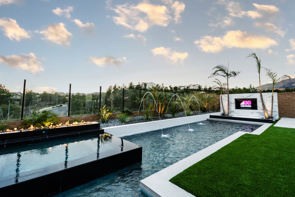 На фото: угловой бассейн среднего размера на заднем дворе в стиле модернизм с покрытием из плитки с