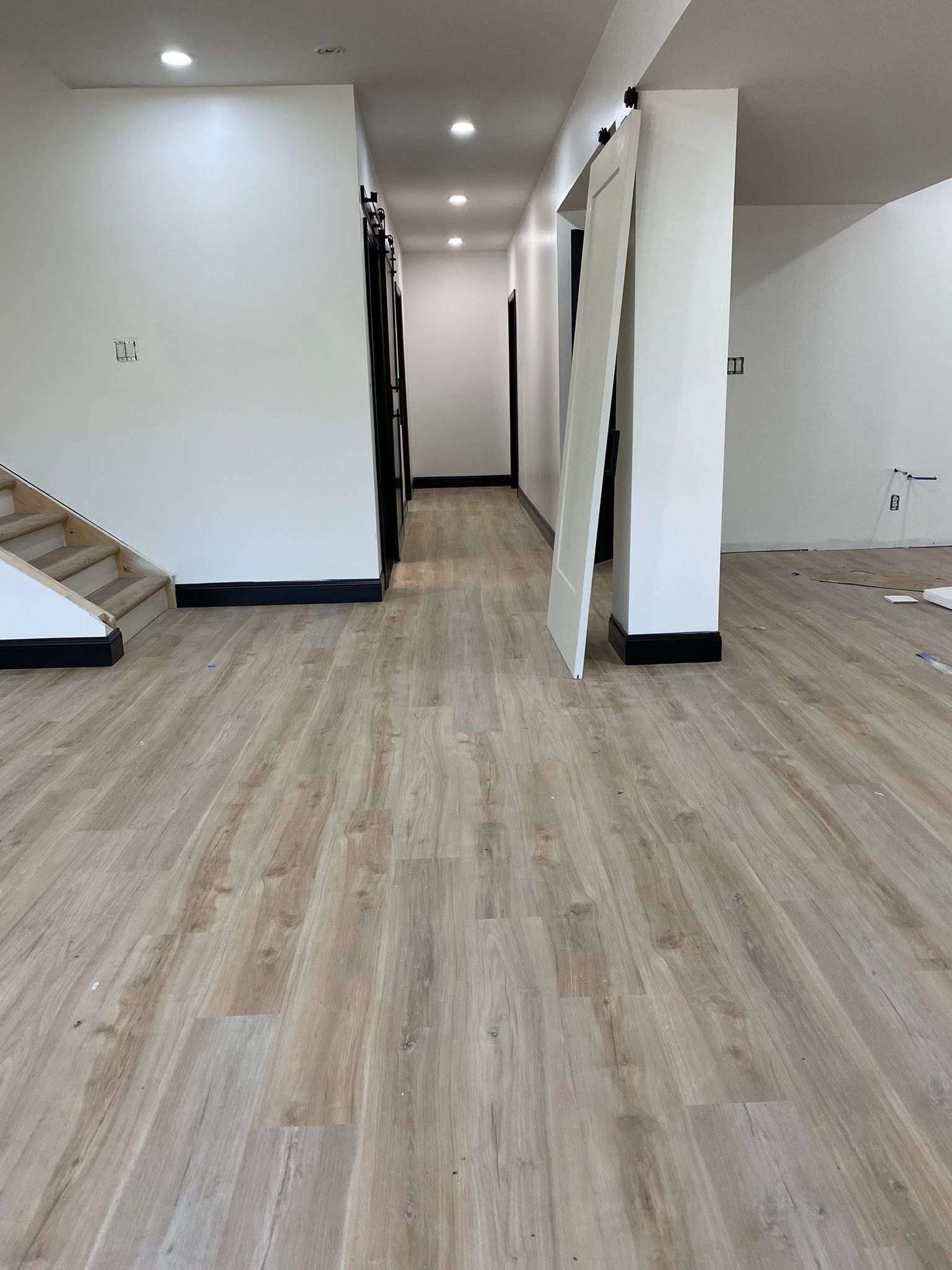 Trendy light wood floor and beige floor basement photo in Indianapolis with white walls and a standard fireplace