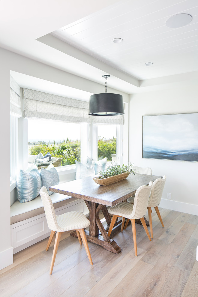 Design ideas for a beach style dining room in Los Angeles with grey walls, light hardwood floors and no fireplace.