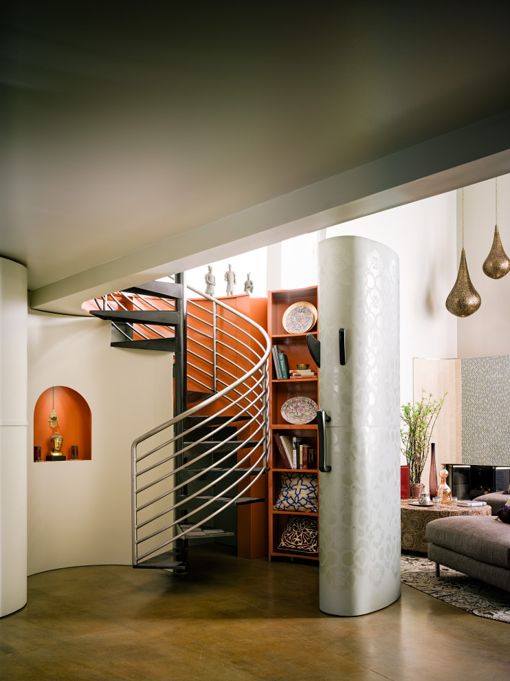 Cette image montre un petit escalier sans contremarche hélicoïdal bohème en bois avec des marches en métal et un garde-corps en métal.