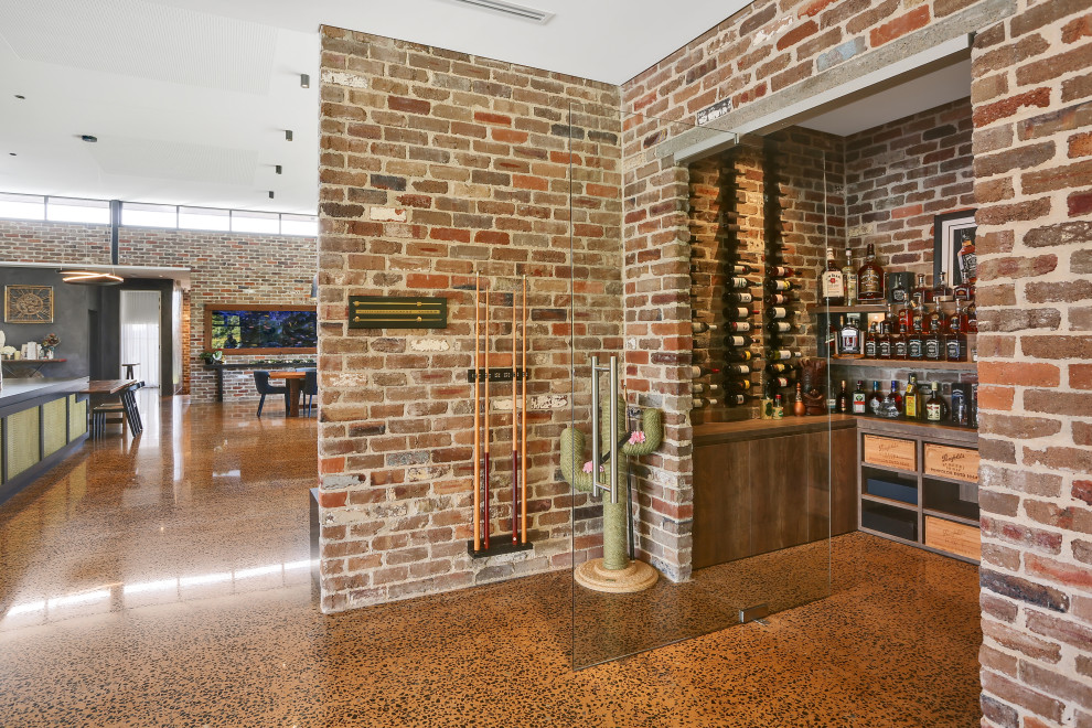 Medium sized contemporary wine cellar in Sydney with concrete flooring, storage racks and brown floors.