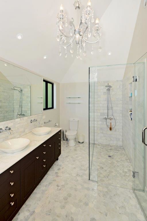 Large traditional master bathroom in Auckland with shaker cabinets, brown cabinets, a freestanding tub, a curbless shower, a two-piece toilet, white tile, stone tile, beige walls, marble floors, a vessel sink and marble benchtops.