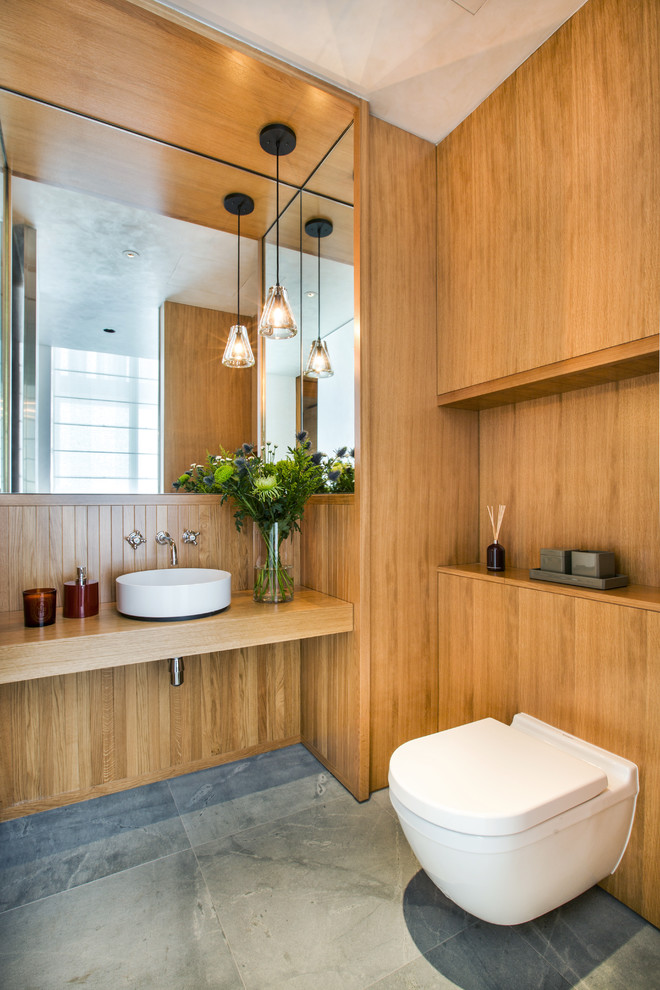 Photo of a mid-sized contemporary bathroom in Singapore with light wood cabinets, blue tile, stone slab, brown walls, marble floors and wood benchtops.