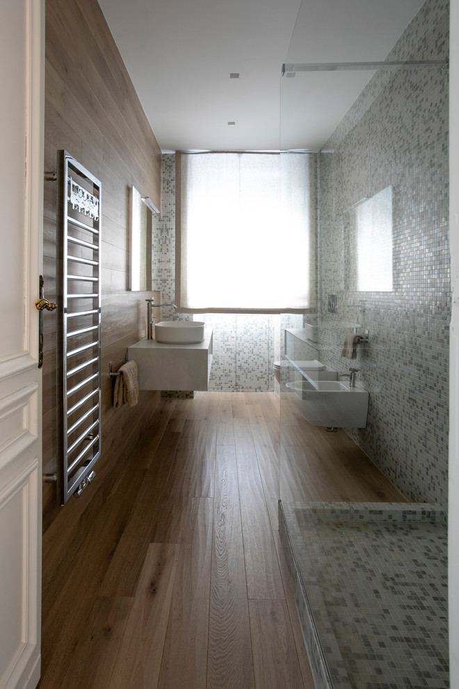 Photo of a large modern 3/4 bathroom in Milan with beaded inset cabinets, light wood cabinets, an open shower, a wall-mount toilet, mosaic tile, light hardwood floors, a vessel sink, laminate benchtops, an open shower and white benchtops.