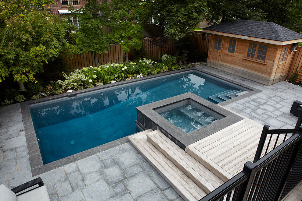 This is an example of a contemporary backyard rectangular pool in Toronto with a hot tub.