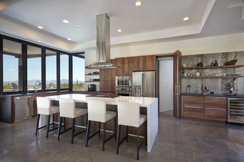 Inspiration for a large modern l-shaped eat-in kitchen in Phoenix with an undermount sink, flat-panel cabinets, dark wood cabinets, quartz benchtops, metallic splashback, metal splashback, stainless steel appliances, concrete floors and with island.